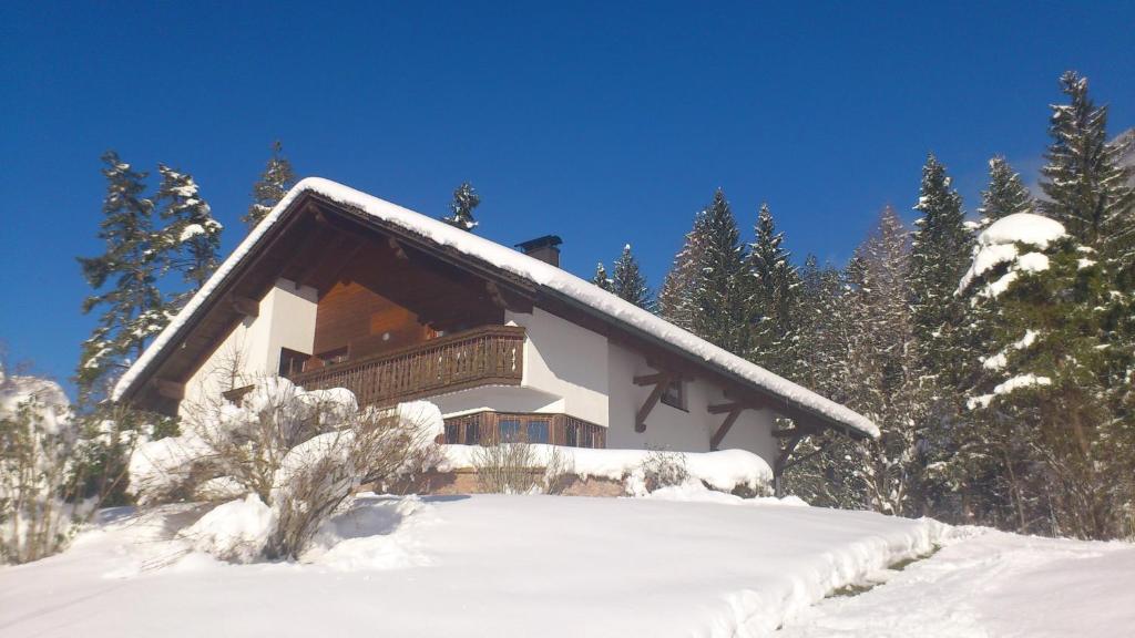 a house covered in snow with trees in the background at Appartment Gertrud Flatz in Sankt Anton im Montafon