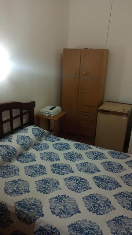 Un dormitorio con una cama azul y blanca y un tocador en Departamentos Urquiza 2 en Mendoza