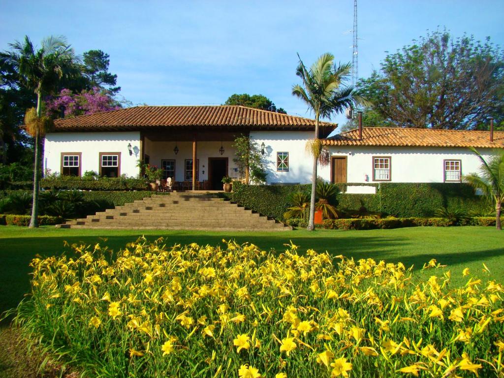 a house with yellow flowers in front of it at Fazenda Capoava in Itu