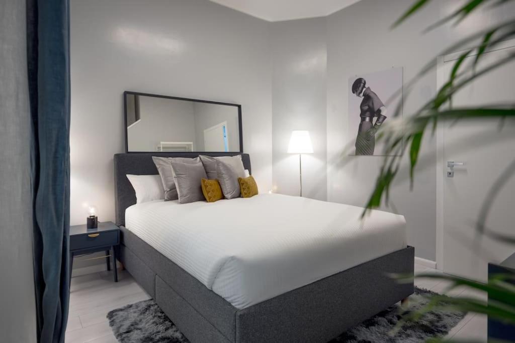a bedroom with a large white bed with a mirror at Spiga Fashion Apartment by Montenapoleone Living in Milan
