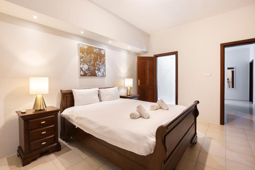 Un dormitorio con una cama grande con sábanas y almohadas blancas. en Sliema Central Apartment Just Minutes from the Beach by JL, en Sliema