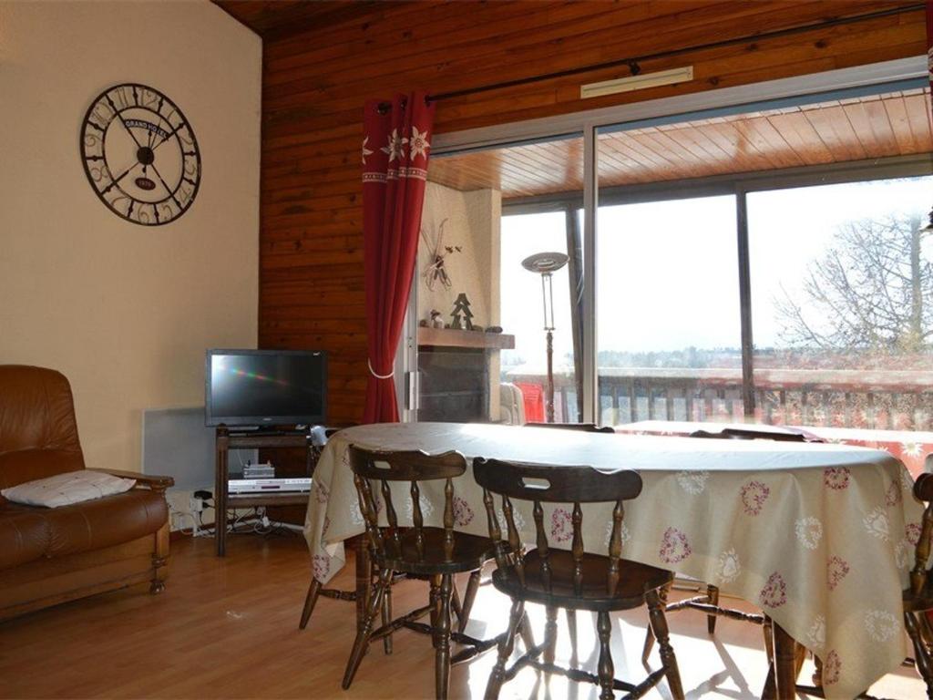 - un salon avec une table et des chaises ainsi qu'une grande fenêtre dans l'établissement Appartement Bolquère-Pyrénées 2000, 3 pièces, 10 personnes - FR-1-592-21, à Bolquère-Pyrénées 2000