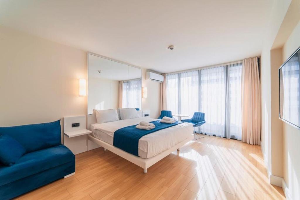 a bedroom with a bed and a blue couch at Orbi City Sea View Apartments in Batumi