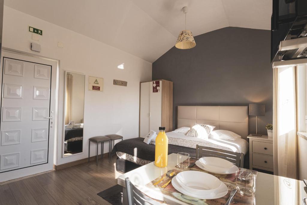 Un dormitorio con una cama y una mesa con platos. en Best Houses 04 - Loft in the Heart of Peniche en Peniche