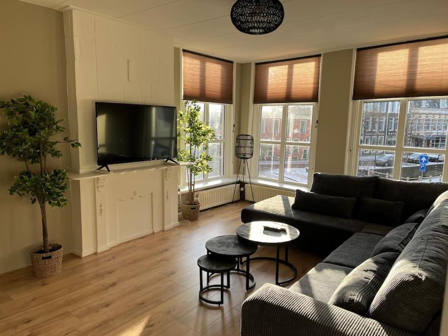 een woonkamer met een bank en een flatscreen-tv bij Appartement centrum Leeuwarden in Leeuwarden