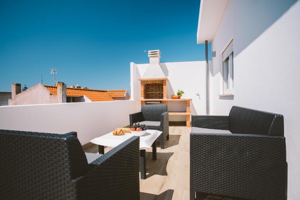 Best Houses 30 - Terrace Peniche في بينيش: شرفة مع كراسي وطاولة على مبنى