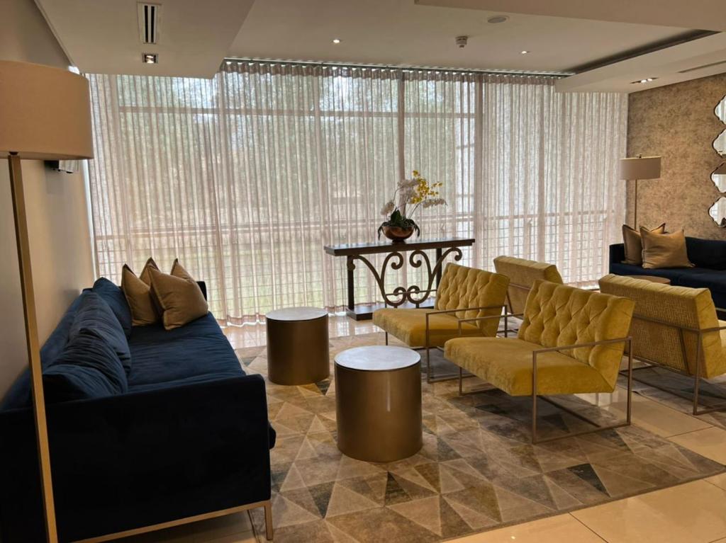 Johannesburg的住宿－Sandton Emperor Apartment，客厅配有沙发、椅子和桌子