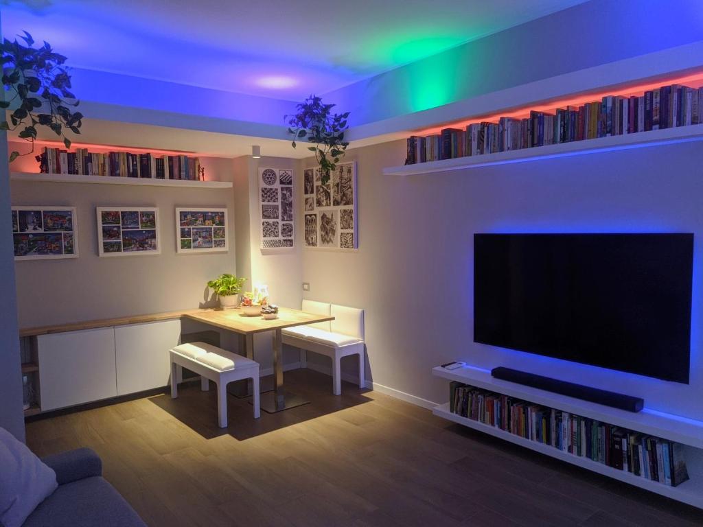 een woonkamer met een tafel en een grote tv bij Relax in Milano - Ventura - Lambrate - Città Studi in Milaan