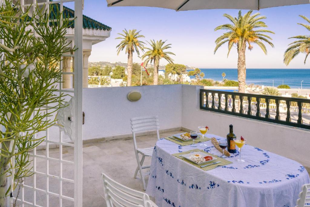 a table on the balcony with a view of the ocean at Appartement avec Terrasse VUE MER in La Marsa