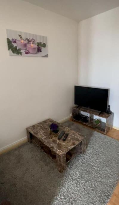 a living room with a coffee table and a flat screen tv at APPARTEMENT DISCRET POUR VOUS in Chalon-sur-Saône