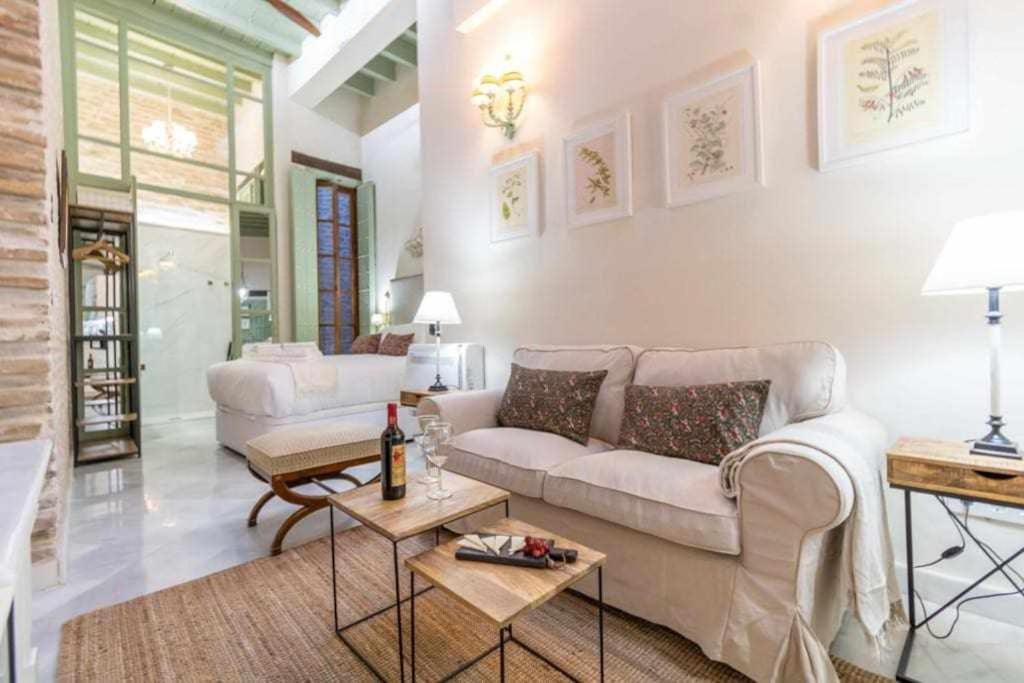 uma sala de estar com um sofá e uma mesa em Judería de Sevilla I Luxury Apartments em Sevilha