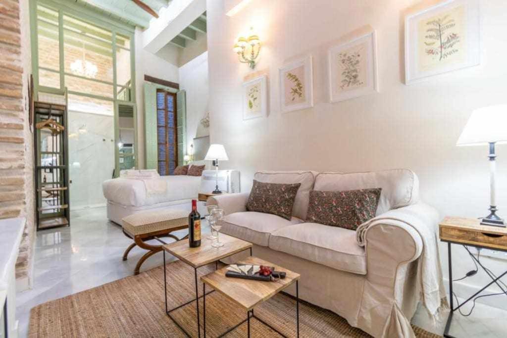 a living room with a couch and a table at Judería de Sevilla I Luxury Apartments in Seville