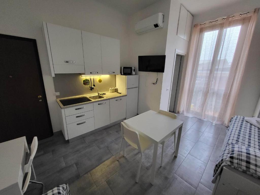 a kitchen with white cabinets and a table and a sink at Masco apartments in Milan