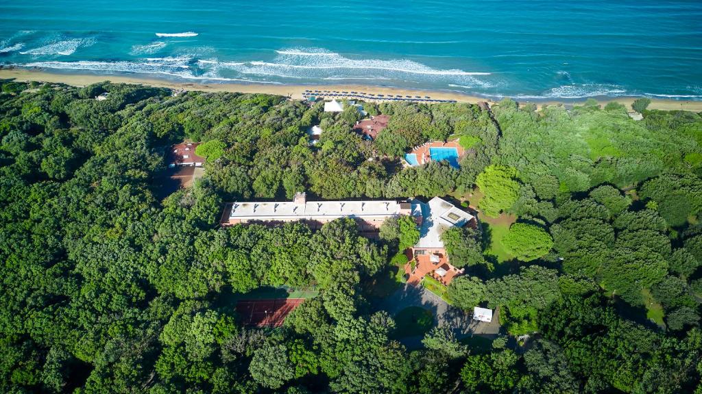 eine Luftansicht eines Hauses im Wald neben dem Meer in der Unterkunft Park Hotel I Lecci in San Vincenzo