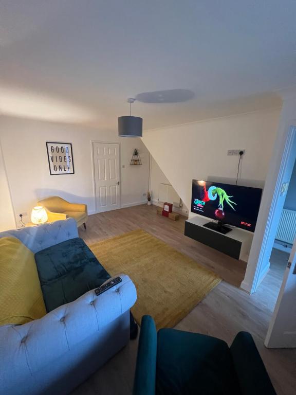 een woonkamer met een bank en een flatscreen-tv bij Chase View - Dog Friendly - Close to Cannock Chase - Great Motorway Links - Perfect for contractors and leisure in Hednesford