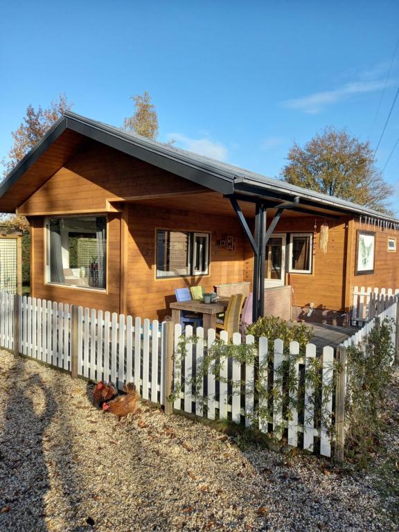 a wooden house with a fence in front of it at 't uiltje in Ermelo