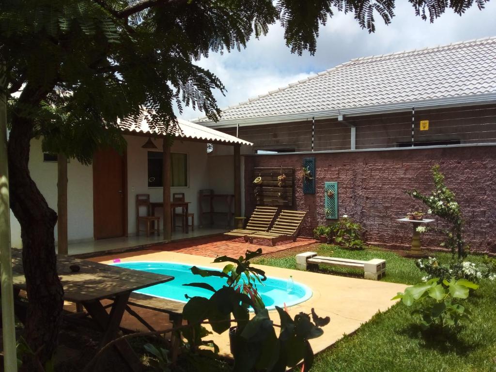 a backyard with a swimming pool and a house at Pousada Canto das Estrelas in Chapada dos Guimarães