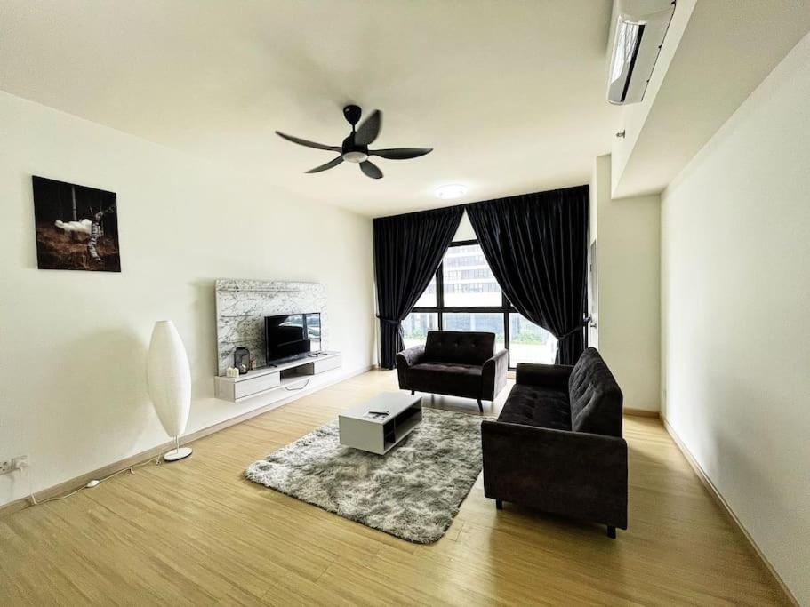 a living room with two chairs and a ceiling fan at Cozy & Comfy Home Dsara Sentral Opposite MRT in Sungai Buluh