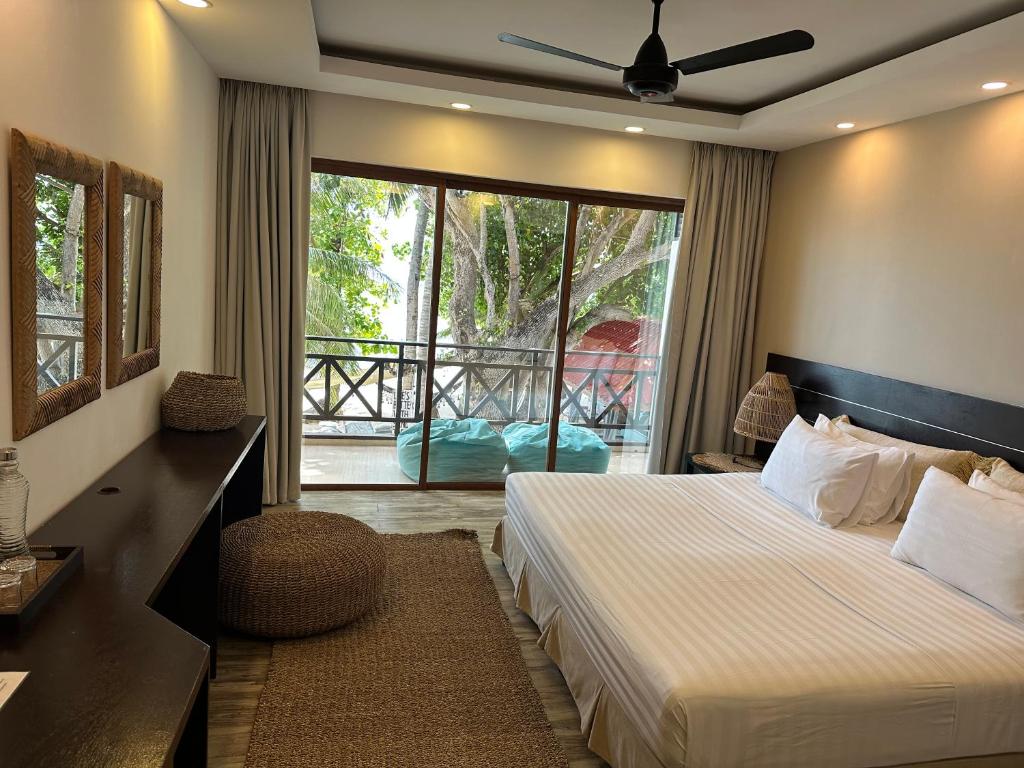 a hotel room with a bed and a balcony at Canopus Retreat Thulusdhoo in Thulusdhoo