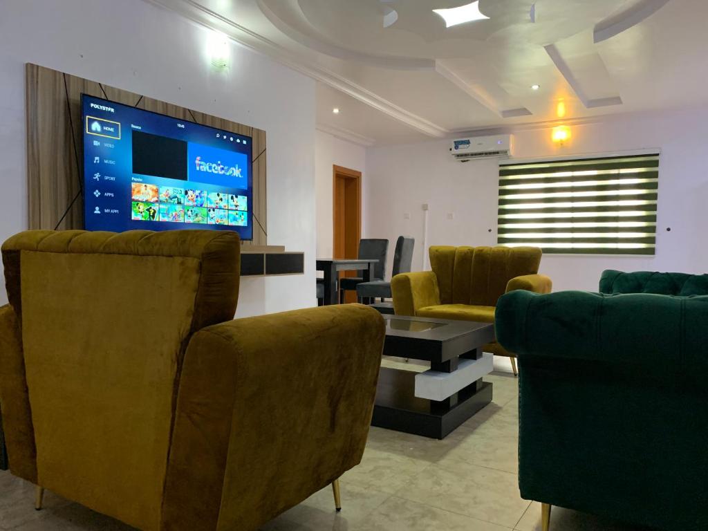 een wachtkamer met stoelen en een flatscreen-tv bij Modern 2BDR APT - Wi-Fi, Kitchenette, Pool & 24hrs Security, Netflix in Ikeja