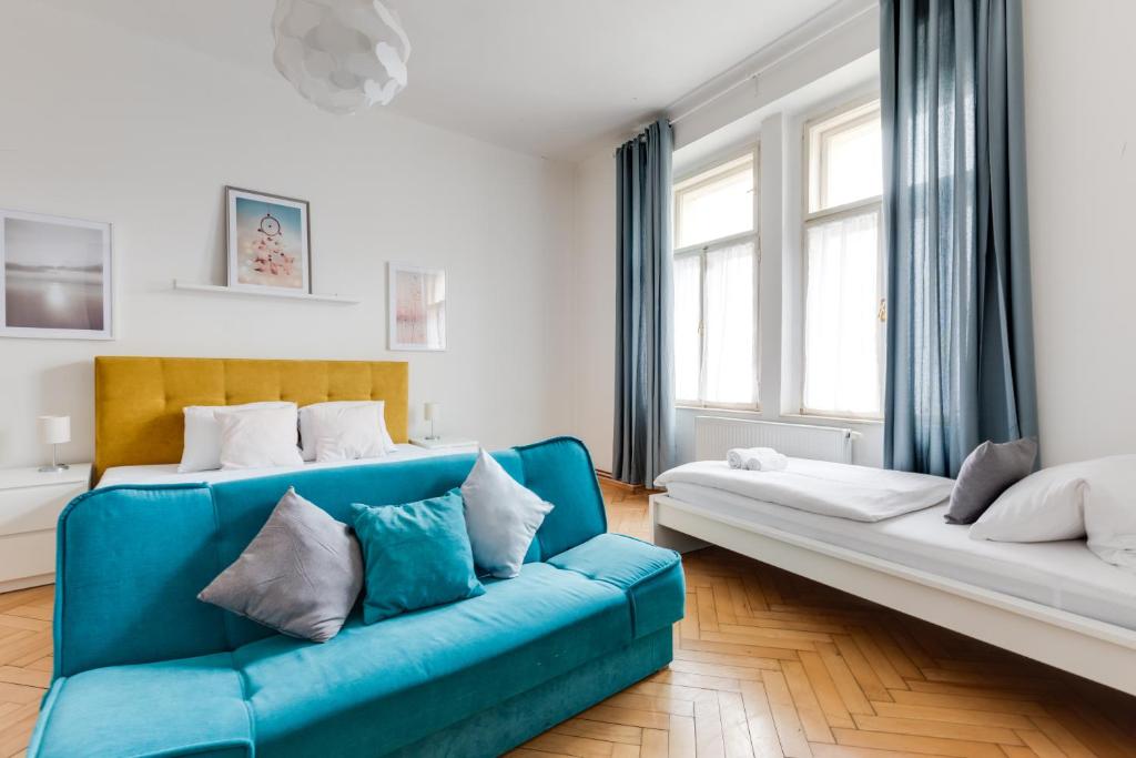 プラハにあるResidence Tesnov Apartmentのリビングルーム(青いソファ、窓2つ付)