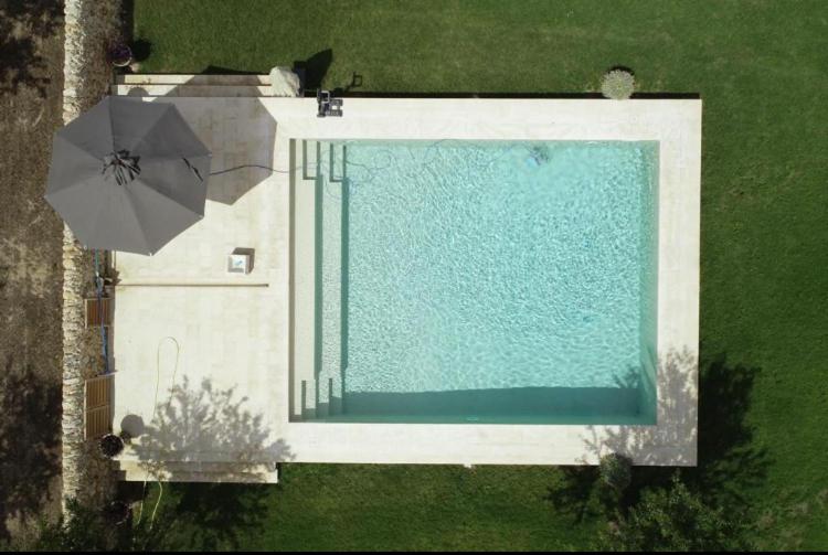 vista sulla piscina con ombrellone di Charming retreat in the sicilian countryside a Vittoria