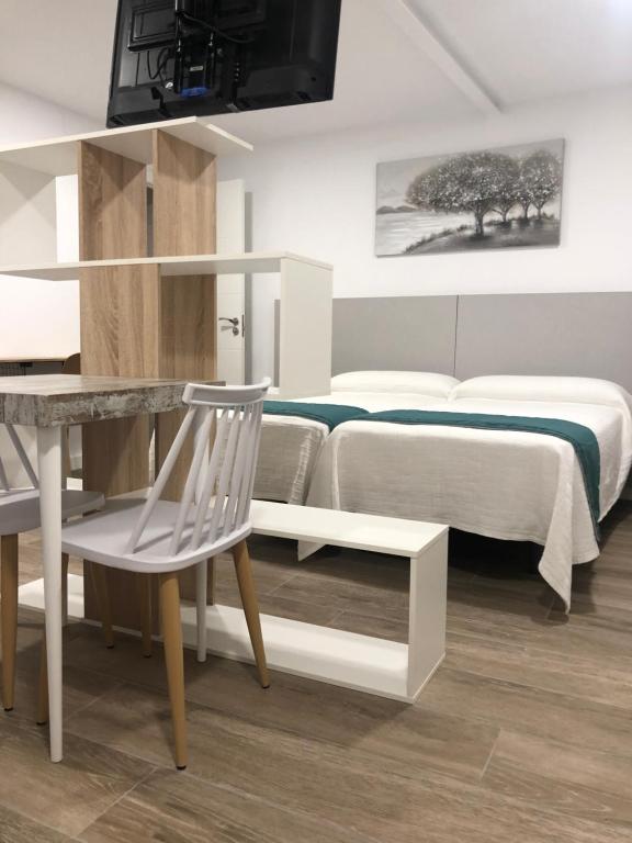 a bedroom with a bed and a desk and a chair at RoomConcept Hostel in Santo Domingo de la Calzada