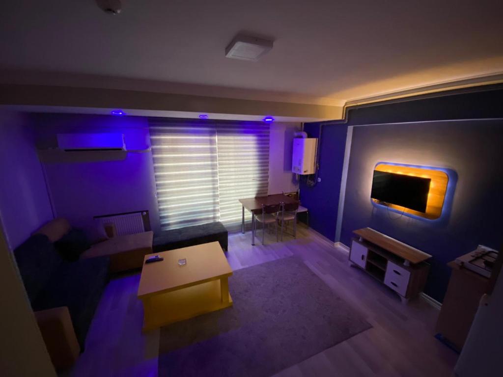 uma sala de estar com iluminação roxa e uma mesa em 8 Plus Apart em Buca