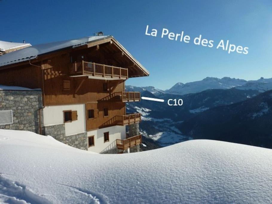 un edificio en la cima de una montaña cubierta de nieve en La Perle des Alpes C10 Apart.4* #Yolo Alp Home, en Villard-sur-Doron