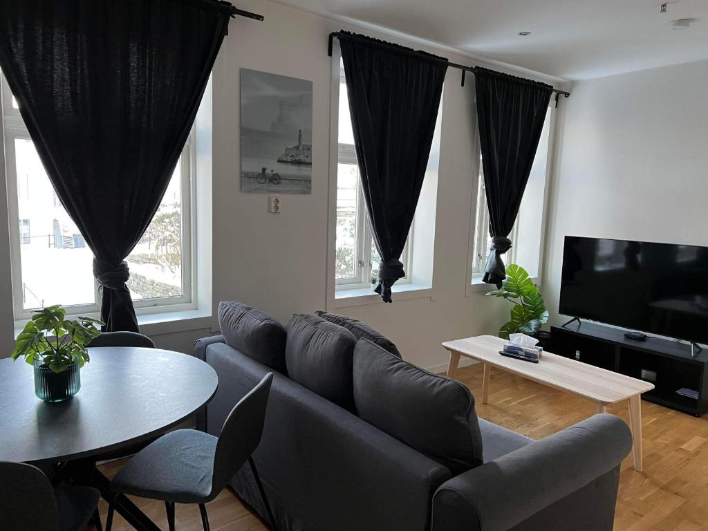 una sala de estar con un sofá y una mesa en Fløyen Apartment, en Bergen