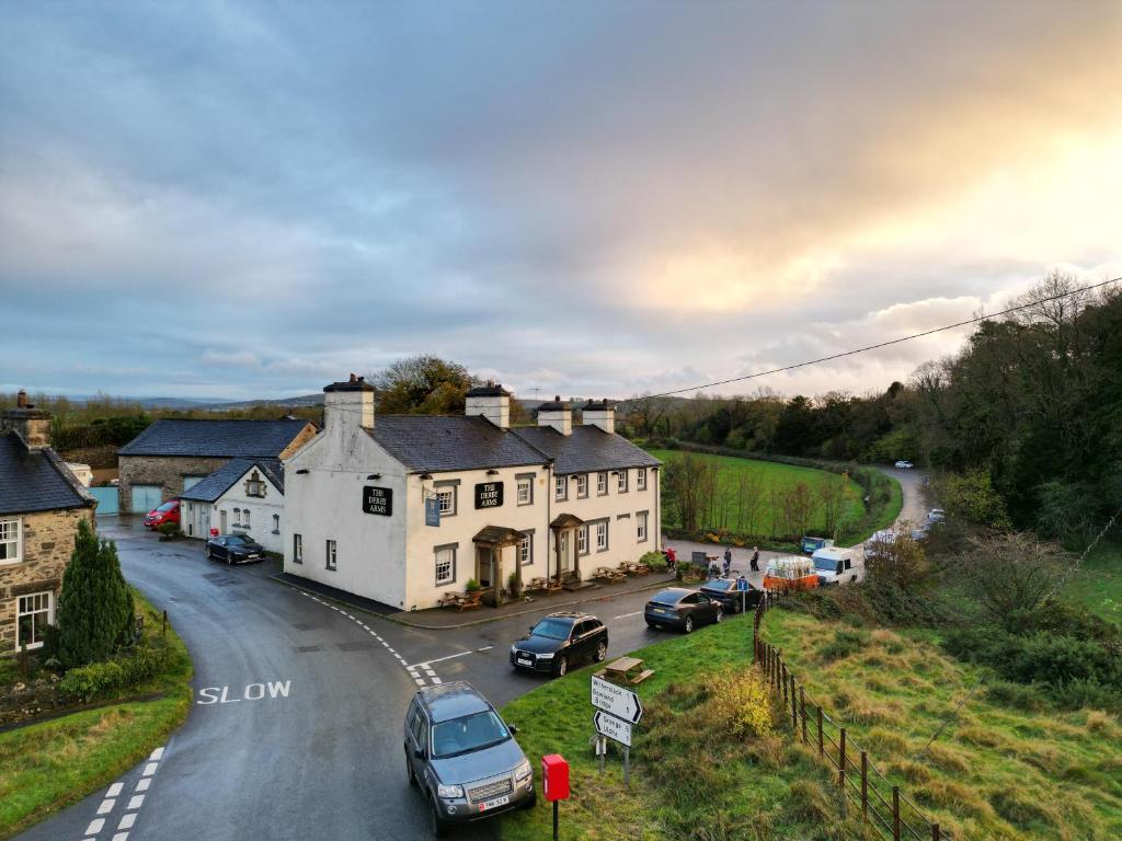 un pequeño pueblo con coches aparcados en la carretera en The Derby Arms Witherslack en Grange Over Sands