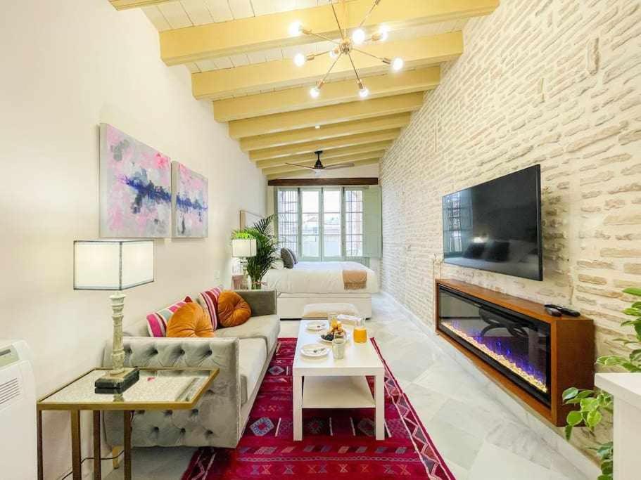 a living room with a couch and a fireplace at Juderia de Sevilla VI Luxury Apartments in Seville