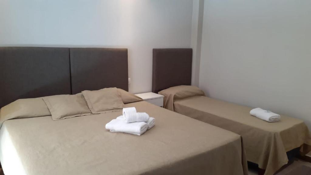 Habitación con 2 camas y toallas plegables. en Hotel Firenze en Necochea