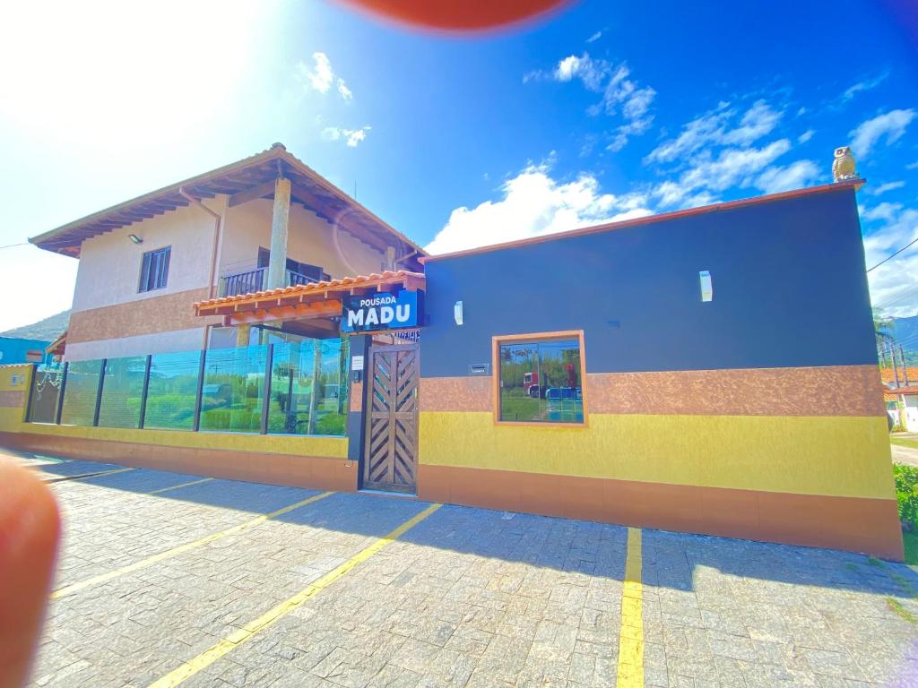 um edifício com um sinal mutico na lateral em Pousada Chales Madu em Ubatuba