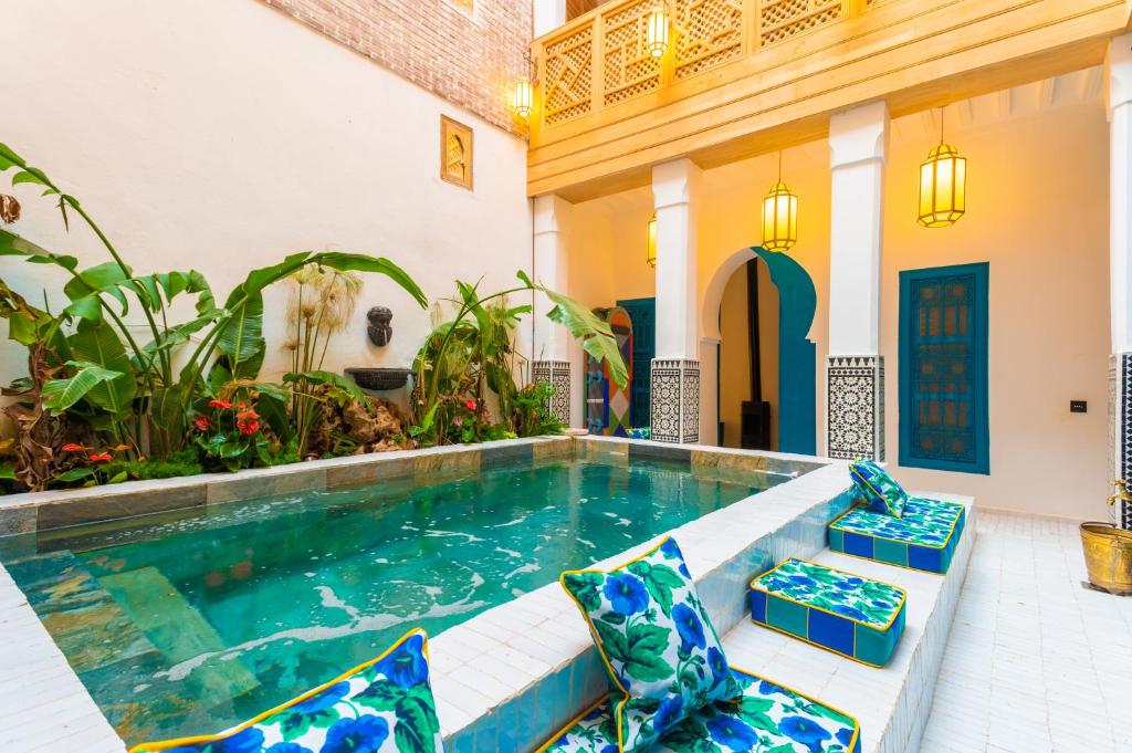 a swimming pool in a house with blue and white at Riad Tibibt in Marrakesh