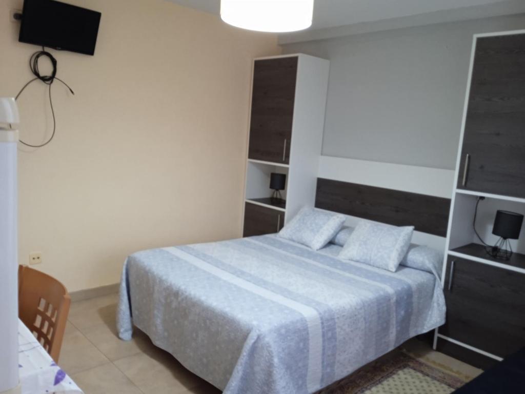 1 dormitorio con 1 cama y TV en Bueu: studio Con vistas al mar- 1 room - 2 persons, en Bueu
