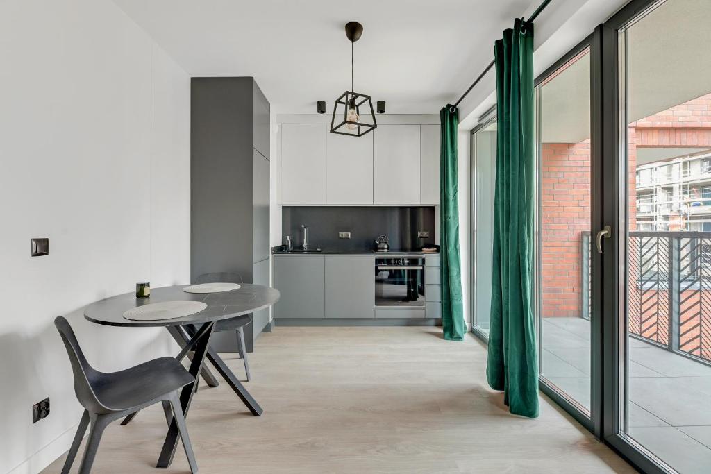 a kitchen and dining room with a table and chairs at Dom & House - Apartments Old Town Scala in Gdańsk