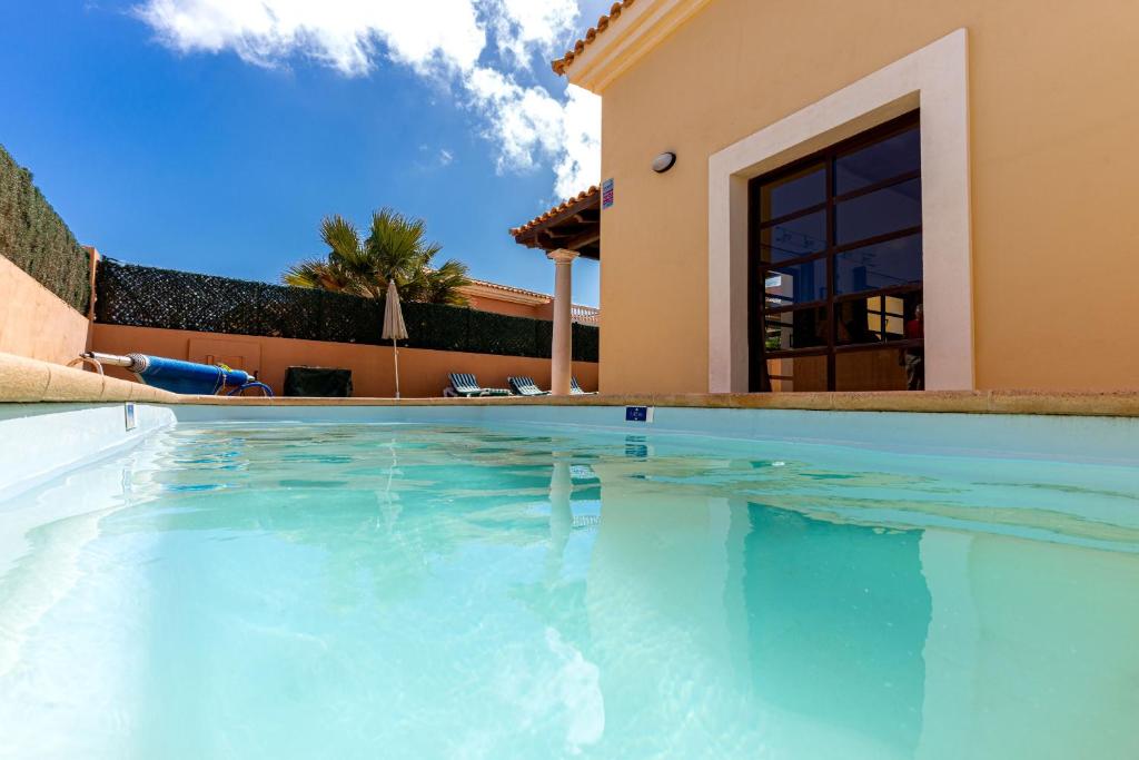 a large swimming pool in front of a house at Villa Serenity Private Pool Corralejo By Holidays Home in Corralejo