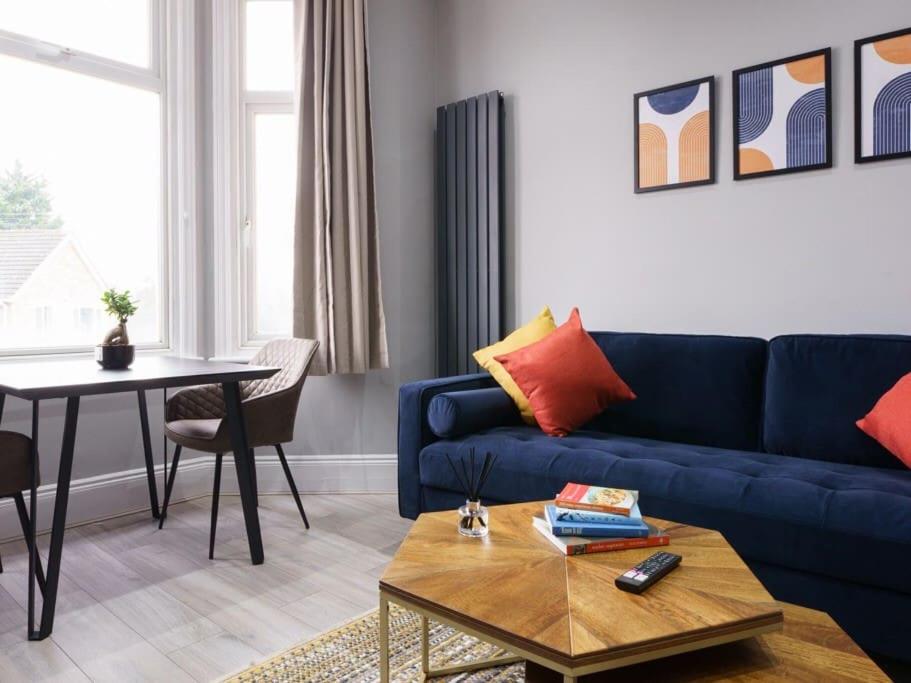 a living room with a blue couch and a table at Modern apartment near Wembley Stadium in London