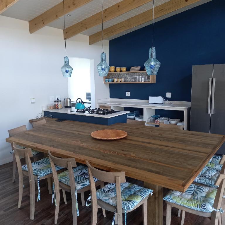 a kitchen with a large wooden table and chairs at Let the good times roll-with inverter and wifi in Cape St Francis