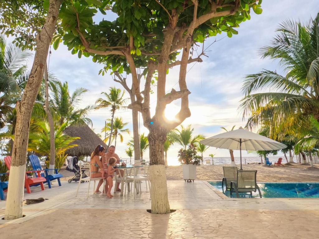 un grupo de personas sentadas en una mesa en la playa en Quinta del Mar La Joya, en Tolú