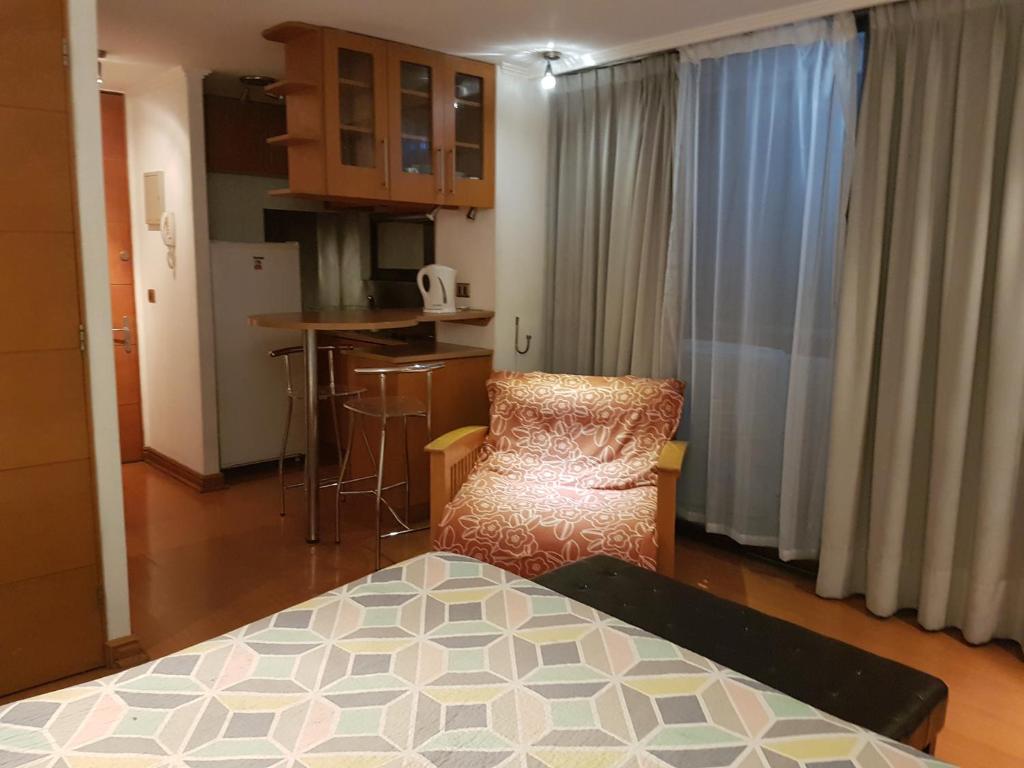 a room with a table and a chair and a kitchen at Departamento amplio en Suite, Costanera Center in Santiago