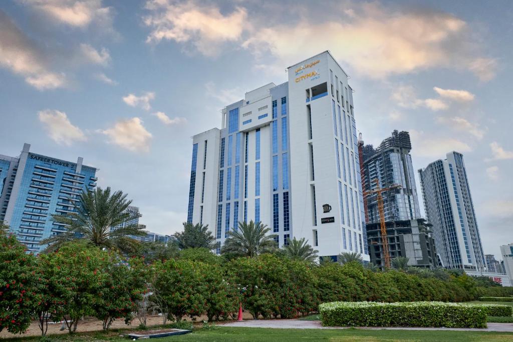 a tall white building in the middle of a city at Citymax Hotel Business Bay in Dubai