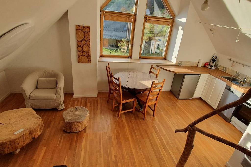 een woonkamer met een tafel en stoelen en een keuken bij Gîte La Cochette in Corbel
