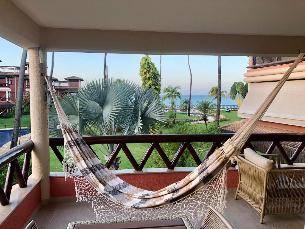 un balcón con hamaca y vistas al océano en Cumbuco Dream Village 602 V en Cumbuco