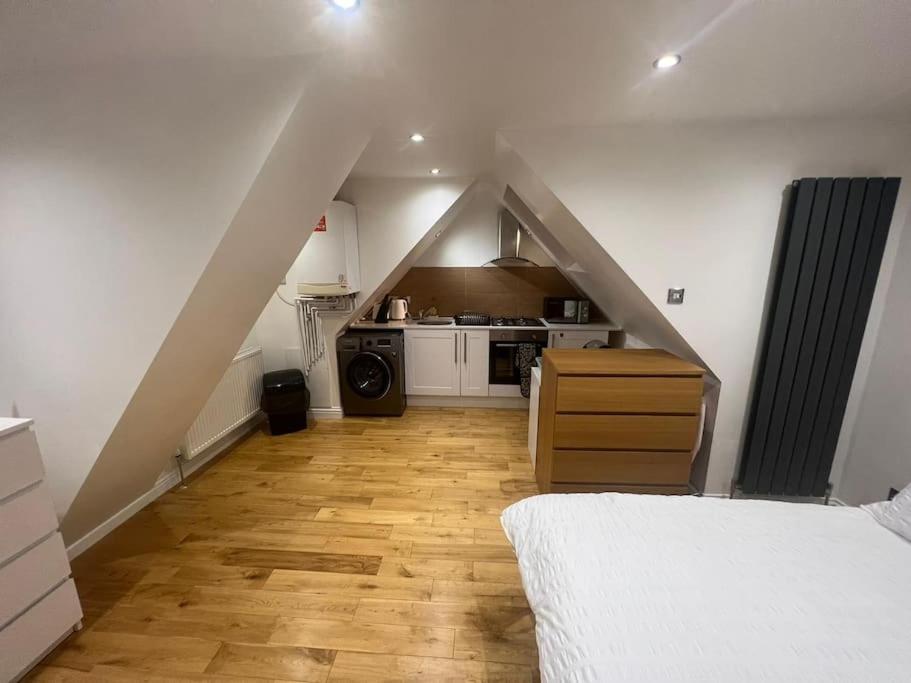 a room with a bed and a kitchen in a attic at Hampden Rd N8,Studio Flat in London