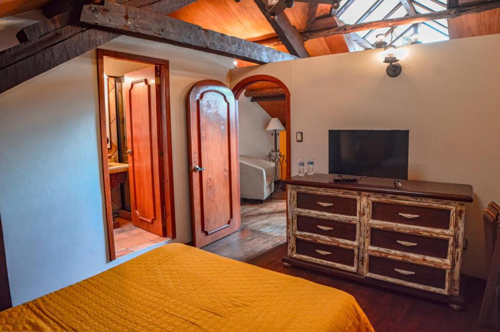 ein Schlafzimmer mit einem Bett und einem TV auf einer Kommode in der Unterkunft Casa de los Arcángeles in San Cristóbal de las Casas