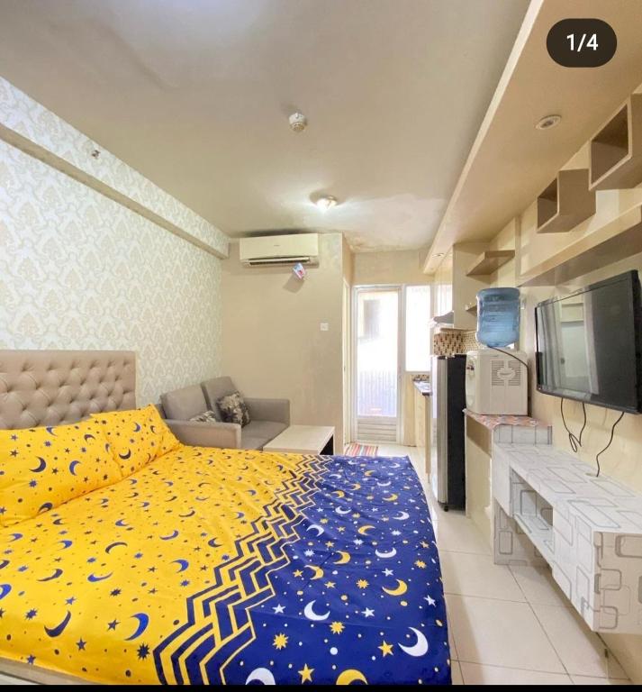 um quarto com uma cama, um sofá e uma televisão em Sewa Apartemen Kalibata City by The Best em Jacarta