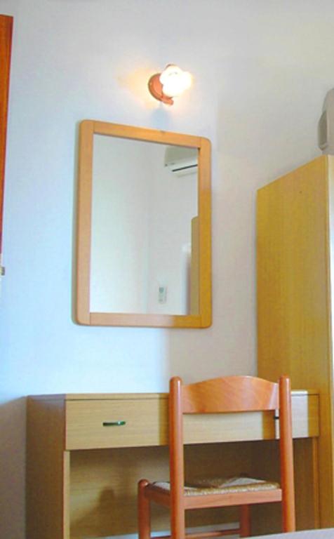 a mirror on a wall with a table and a chair at Ludovica Room in Positano