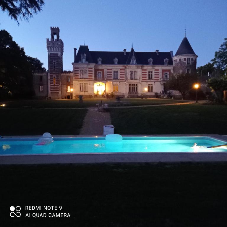 Stara rezydencja z basenem przed nią w obiekcie la tour carrée d'un chateau w mieście Auzouer-en-Touraine